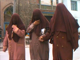 Whether because of religious reasons or as a filter for the dust and desert sand, some Uyghhur women wore the chadur.  Kashgar, Xinjiang.