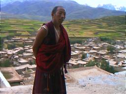 Tibetan monasteries are often, though not always, built on a hill overlooking the town that they serve. Tibetan buildings such as these in the background, usually have earthen roofs which are used for drying hay and crops. Ganzi Lamasery, Sichuan