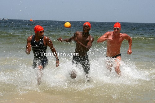 Swimmers exit the water and race to the finish line