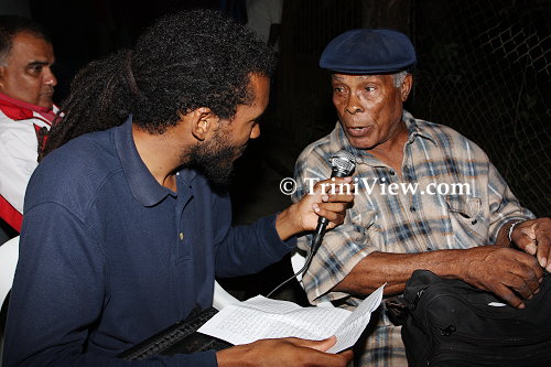 LEFT: A member of Triniview.com interviews Lordrick Espinosa at the wake of Tito Lara