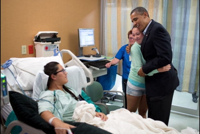 President Barack Obama hugs Stephanie Davies, who helped her friend, Allie Young during the movie theater shootings