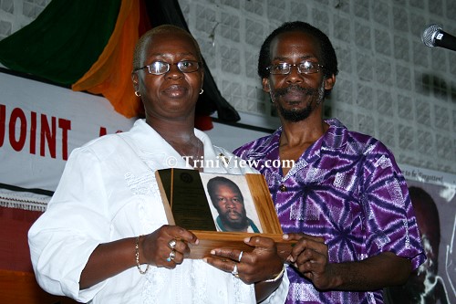 Trevor Nicholas makes a presentation to Yvonne John, the daughter of the late Leroy 'Stammerer' Noel
