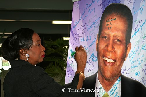 Former Minister of Culture, Joan Yuille Williams signs the picture of Terry Joseph