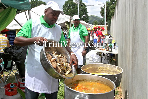 Inter Agency Task Force (IATF) officers (in green) cooking fish broth