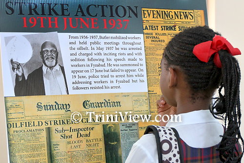 Student reads the exhibited information on the 1930s strikes led by Tubal Uriah 'Buzz' Butler