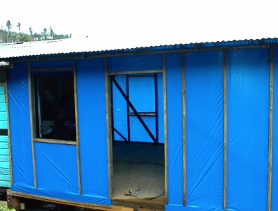 Canadian workers reconstruct Grenada homes with temporary blue tarpaulin